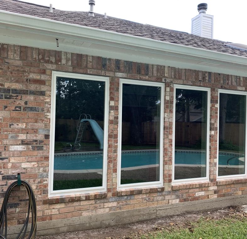 Backyard pool reflected in house windows